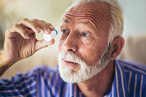 Man Putting Eye Drops Into His Eye